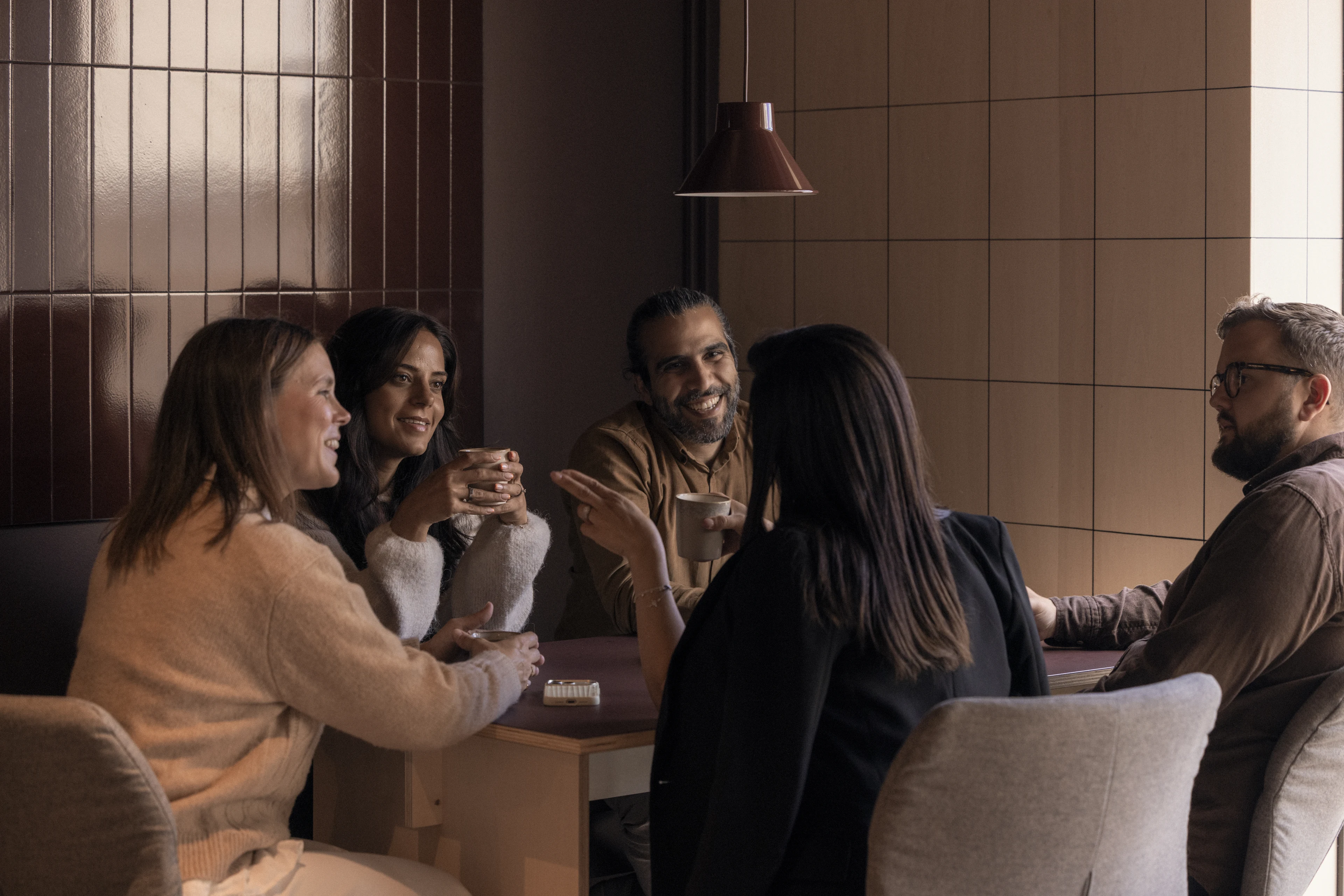 Five colleagues talking in a lounge area.